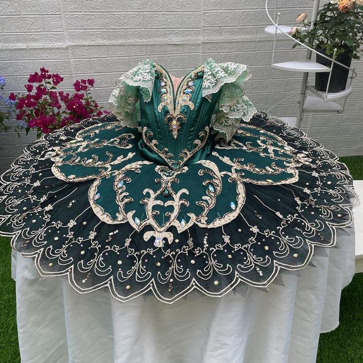 an elaborately designed table cloth on top of a white table with flowers in the background