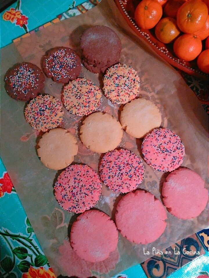 there are many cookies and oranges on the table next to each other, including one with sprinkles