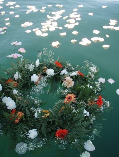 a wreath made out of flowers floating on top of water