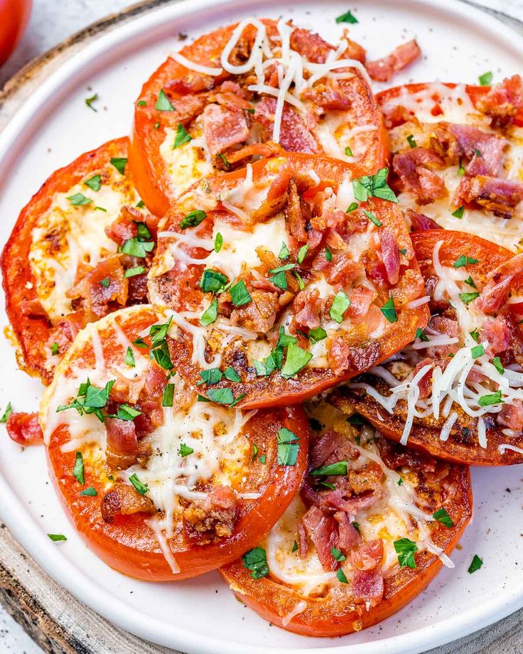 tomatoes with bacon, cheese and parmesan on a white plate