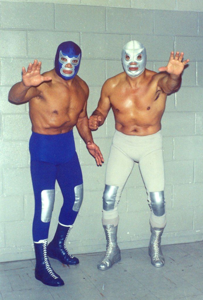 two men in wrestling gear standing next to each other