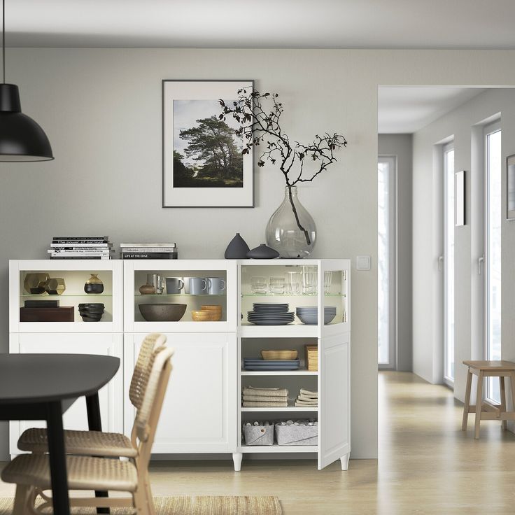 a dining room with white cabinets and chairs