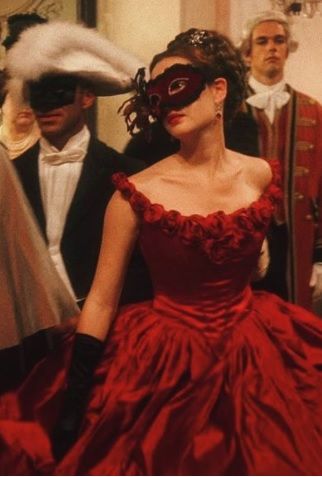 a woman in a red dress with a mask on