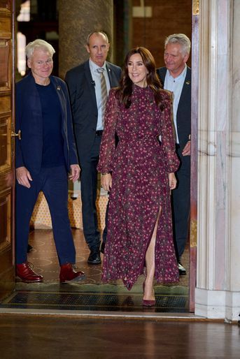 two men and a woman are walking into a building