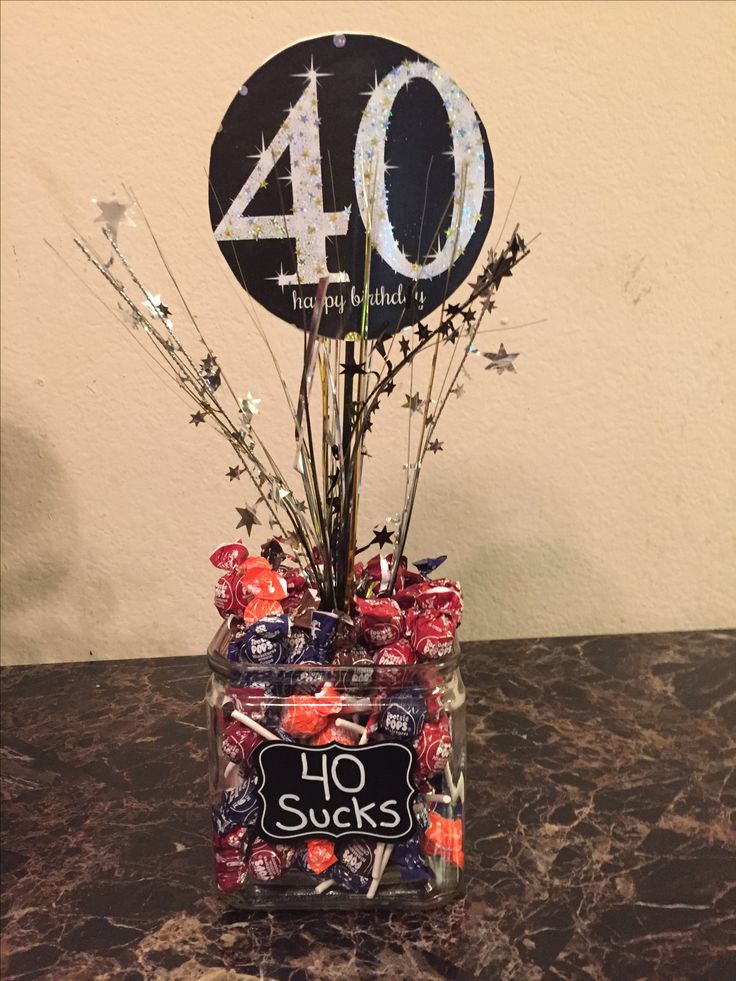 a glass jar filled with candy and candies next to a sign that says 40