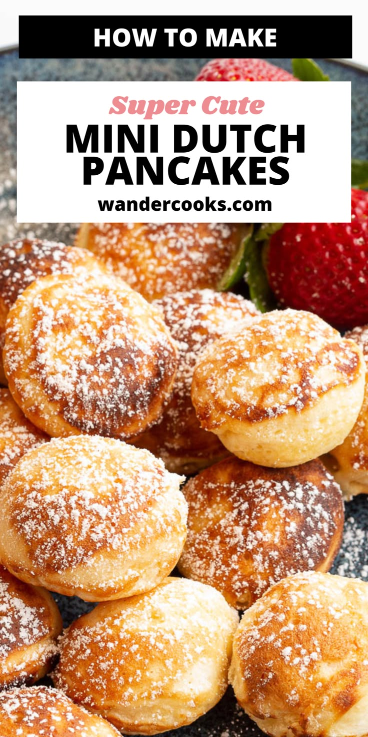 powdered sugar covered mini dutch pancakes on a plate with strawberries in the background