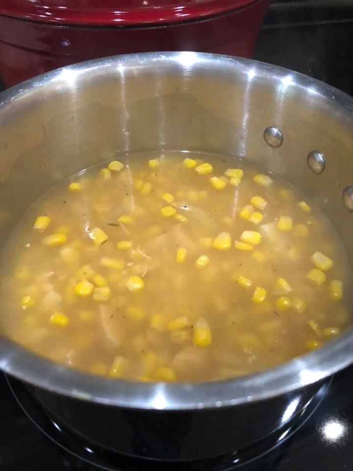 a pot filled with corn sitting on top of a stove