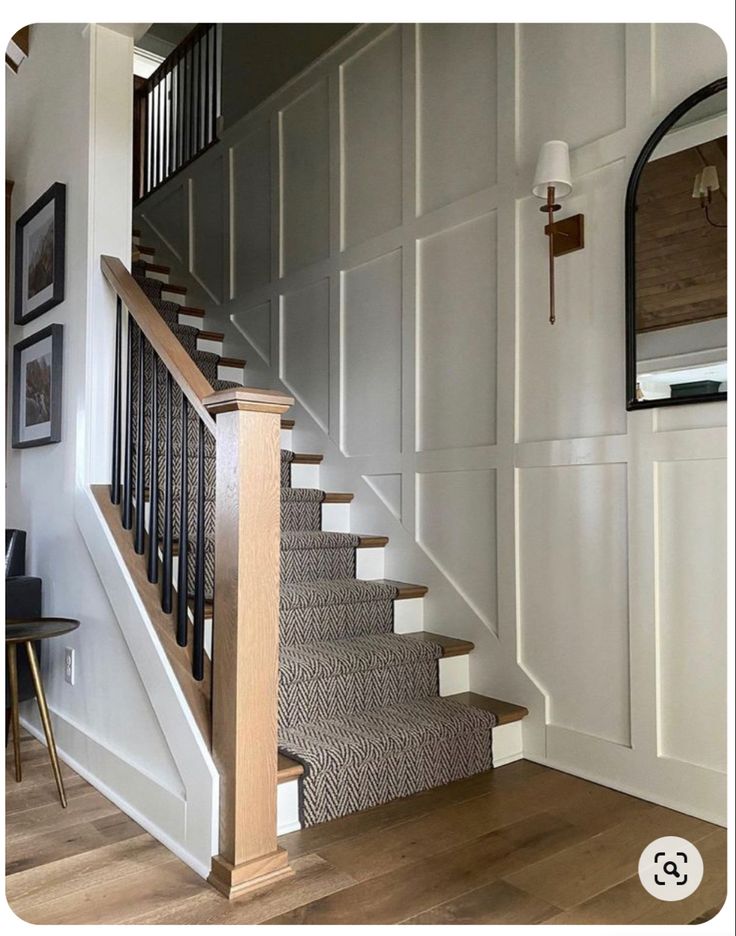 the stairs are made of wood and have metal railings on each side, along with carpeted flooring