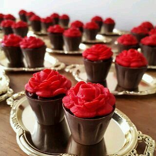 chocolate cupcakes with red frosting sitting on plates