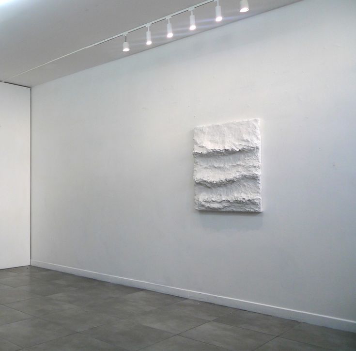 an empty room with two paintings on the wall