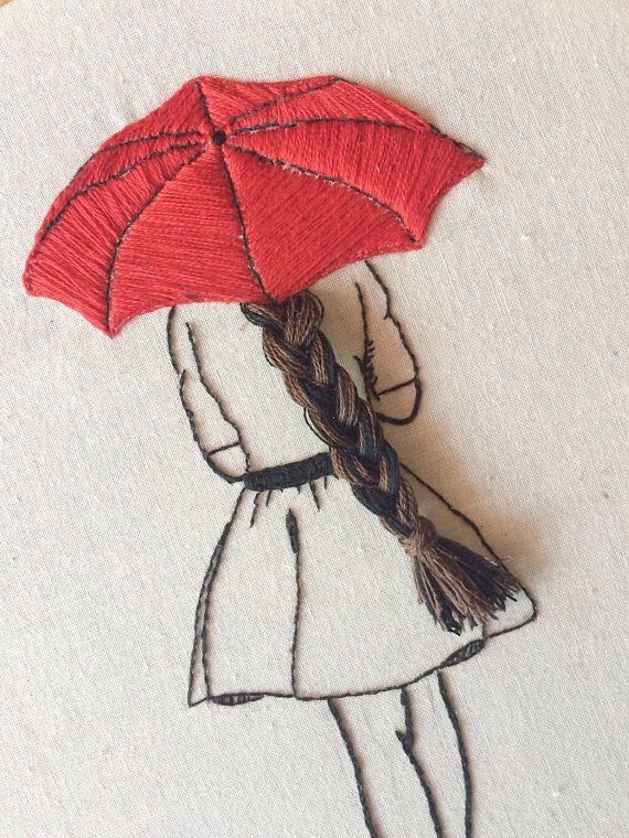 a drawing of a girl with an umbrella in her hand on a piece of fabric