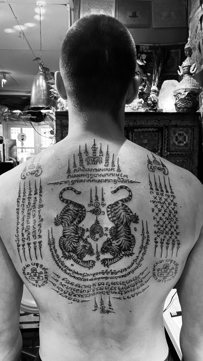 the back of a man with tattoos on his chest