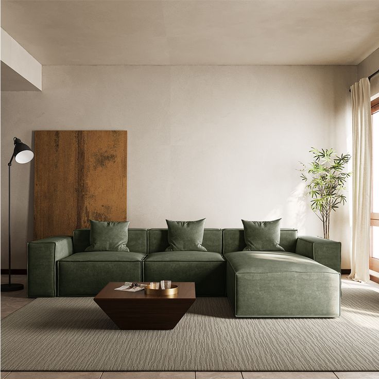 a living room with a green couch and coffee table in front of a large window