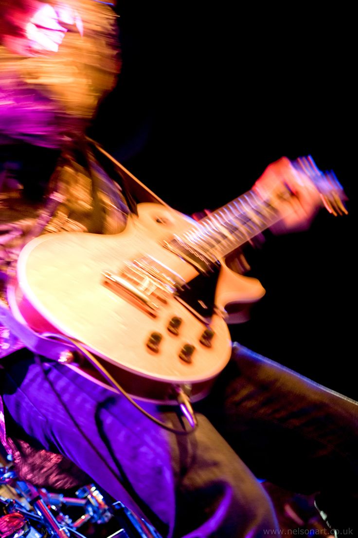 the man is playing his guitar on stage