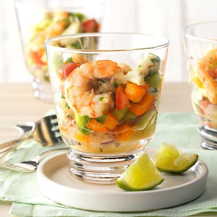 shrimp and vegetable salad served in glass bowls with lime wedges on the side, ready to be eaten