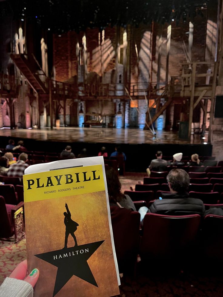 someone holding up a book in front of an auditorium