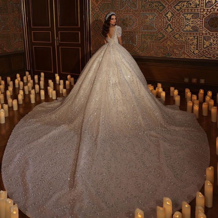 a woman in a white wedding dress standing on the floor with her back turned to the camera