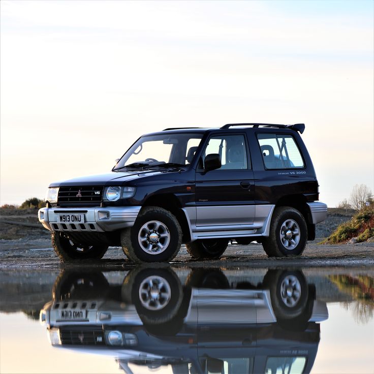 a black suv parked next to a body of water