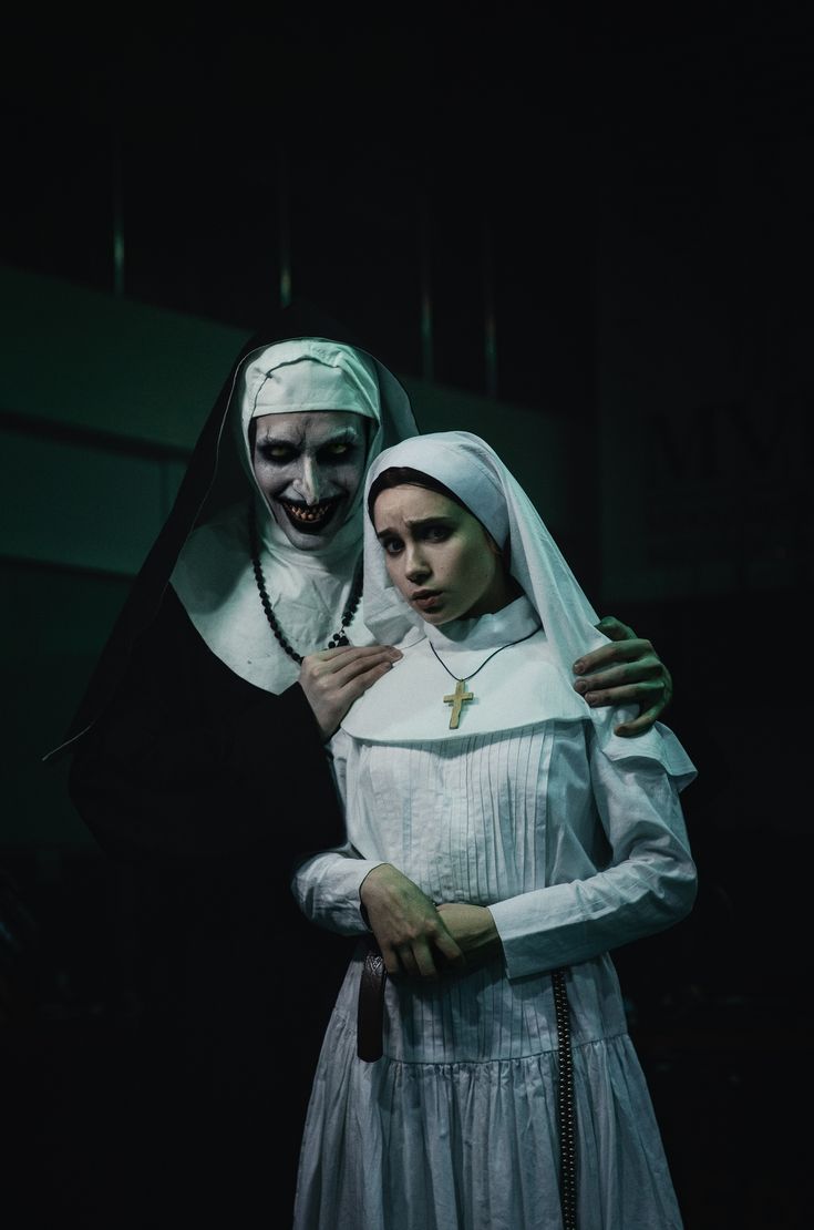 two people dressed in nun costumes standing next to each other with their arms around one another