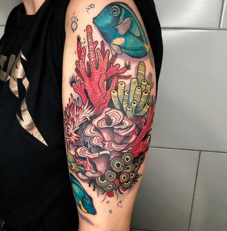 a woman's arm with colorful tattoos on it and an image of corals