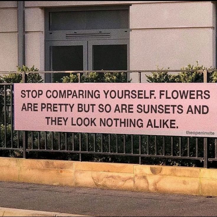 a pink sign that is on the side of a fence