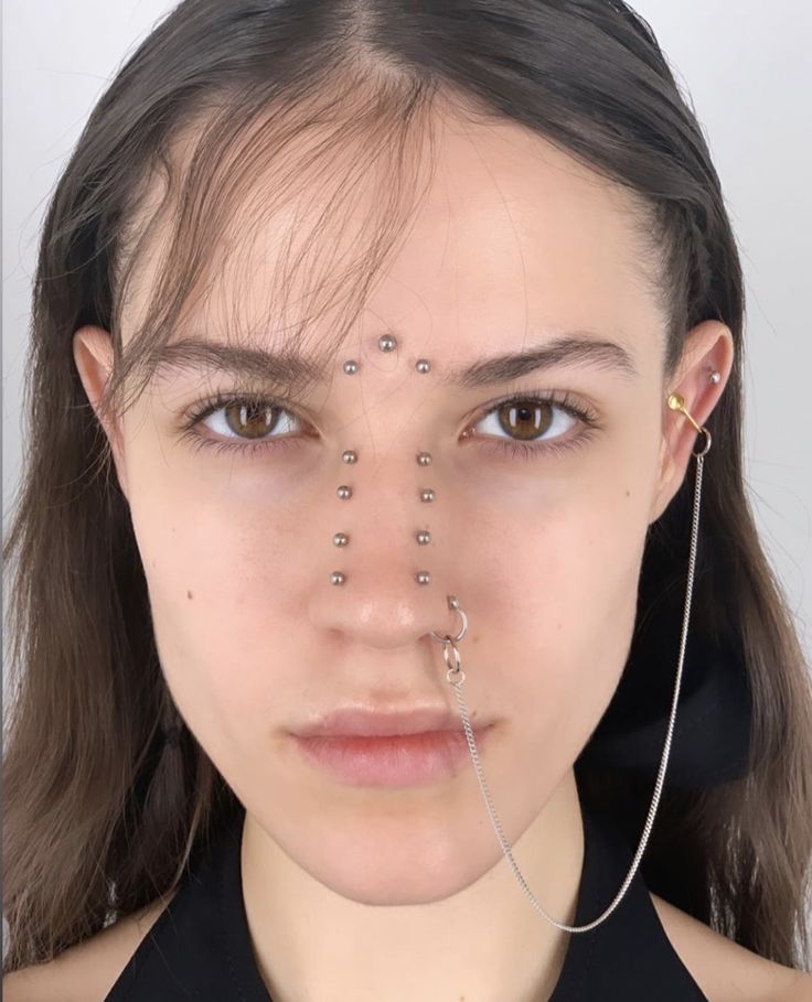 a woman with piercings on her face and nose