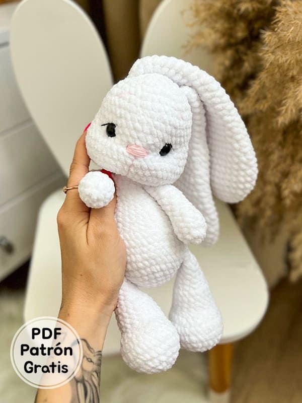 a white crocheted stuffed rabbit sitting on top of a chair