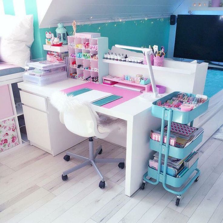 a desk with lots of crafting supplies on it in the corner of a room