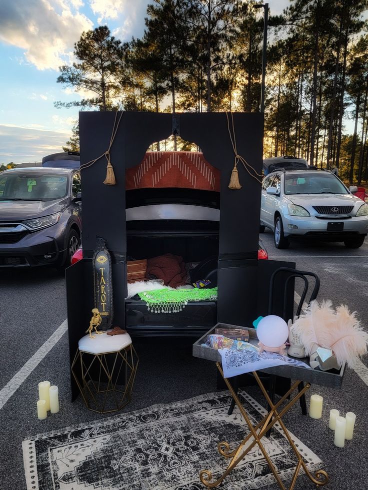 an open oven sitting in the middle of a parking lot next to parked cars and candles