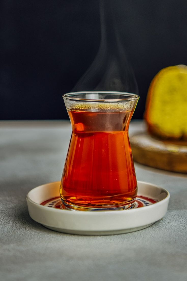 a glass cup filled with liquid sitting on top of a plate