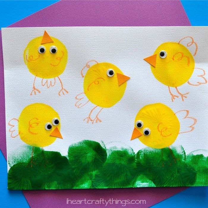 a paper plate with some yellow chicks on it and green leaves in front of it