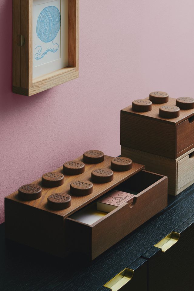 two wooden boxes with cookies in them sitting on a table next to a pink wall