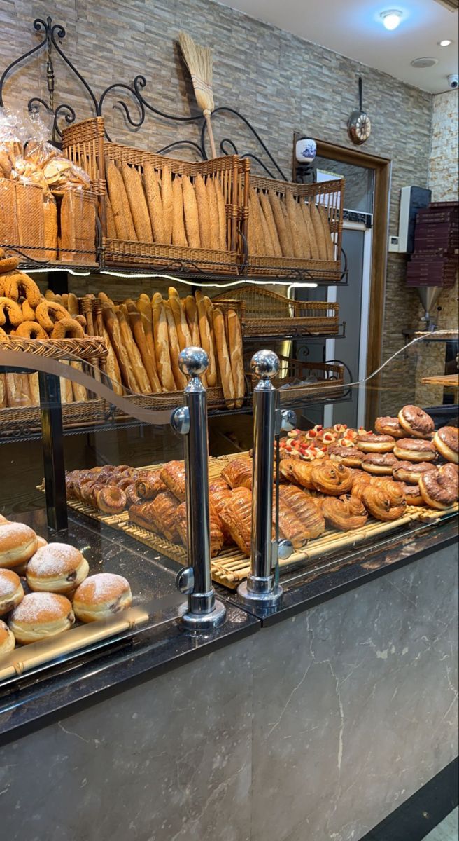 a bakery filled with lots of different types of breads and pastries on display