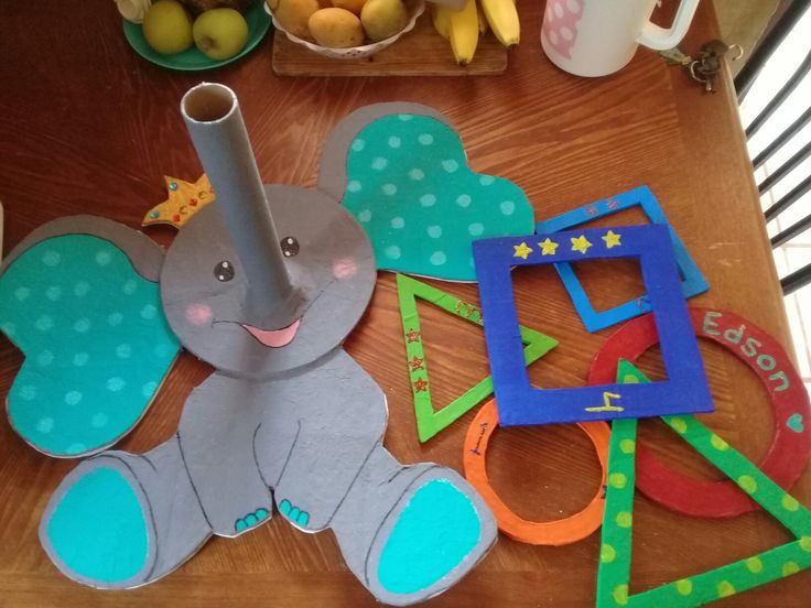 a wooden table topped with paper cut outs and elephant shaped objects on top of it