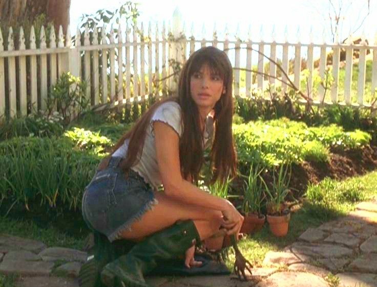 a woman kneeling down next to some plants