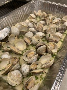 a pan filled with lots of clams on top of a table