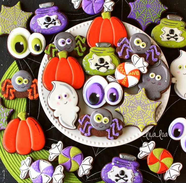 decorated cookies are arranged on a plate for halloween