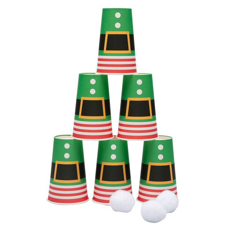 a group of green and red party hats with white balls in the bottom one on top