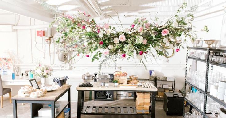 a flower shop with flowers hanging from the ceiling and shelves full of items on display