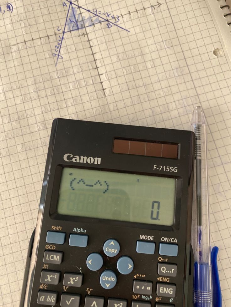 a calculator sitting on top of a piece of paper next to a pen