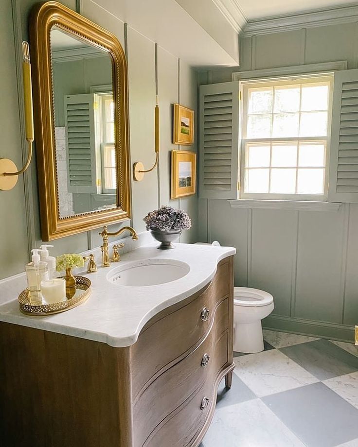 a bathroom with a sink, mirror and toilet in it's centerpieces