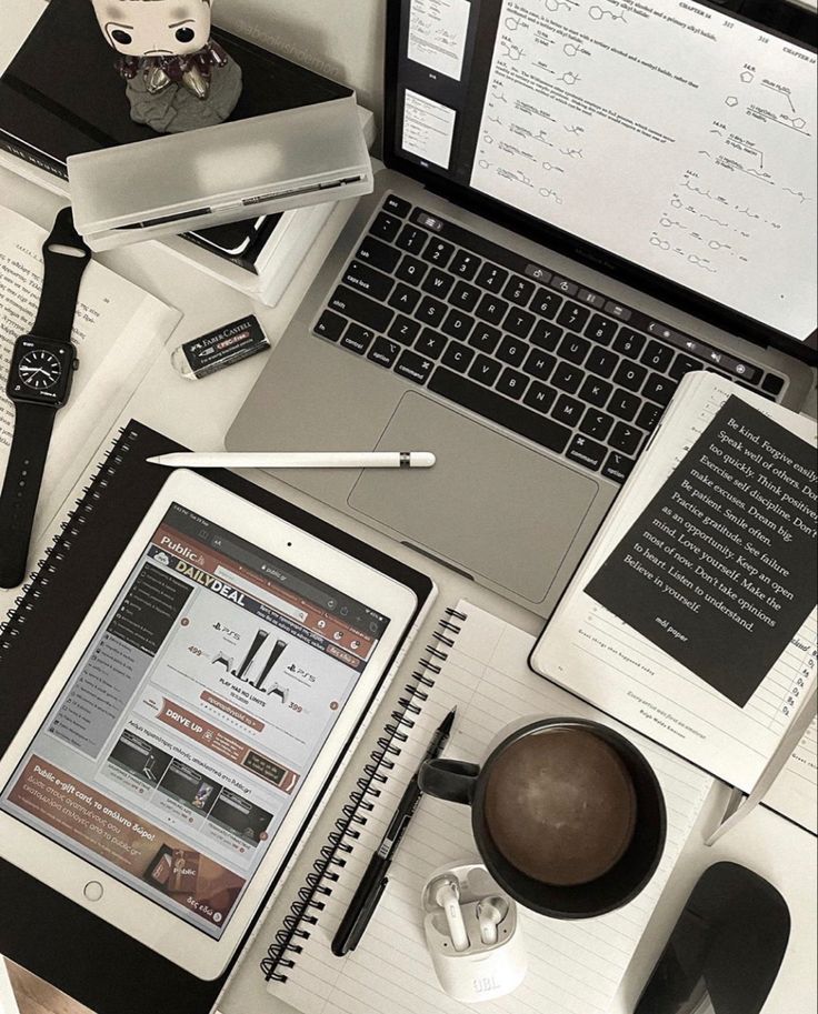 an open laptop computer sitting on top of a desk next to a cup of coffee