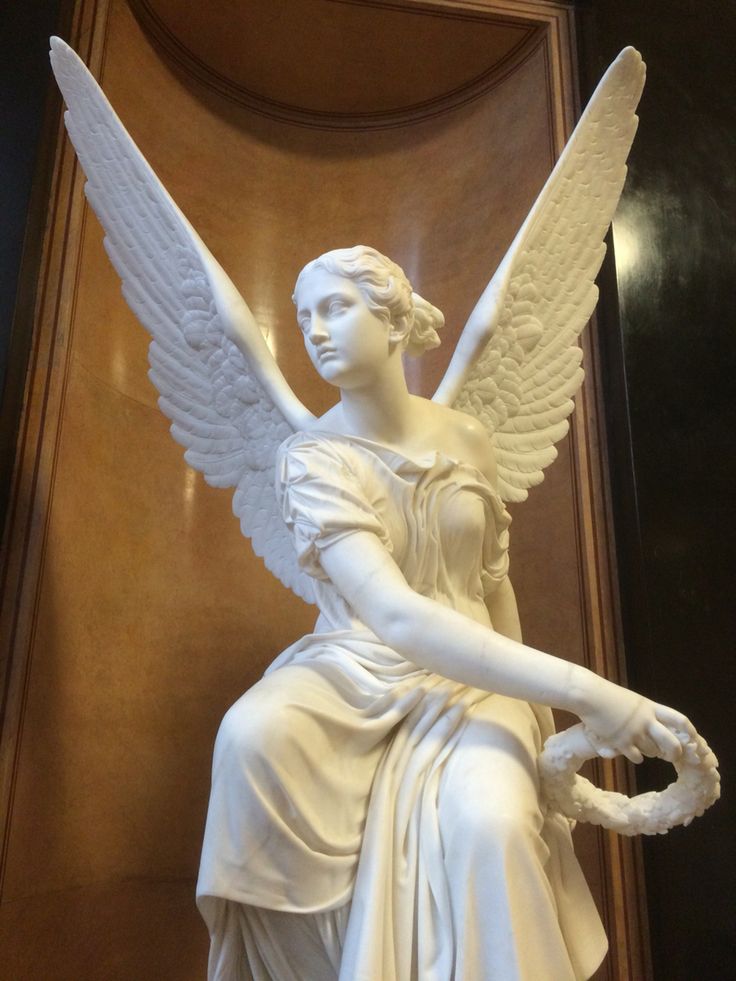 a statue of an angel sitting on top of a table