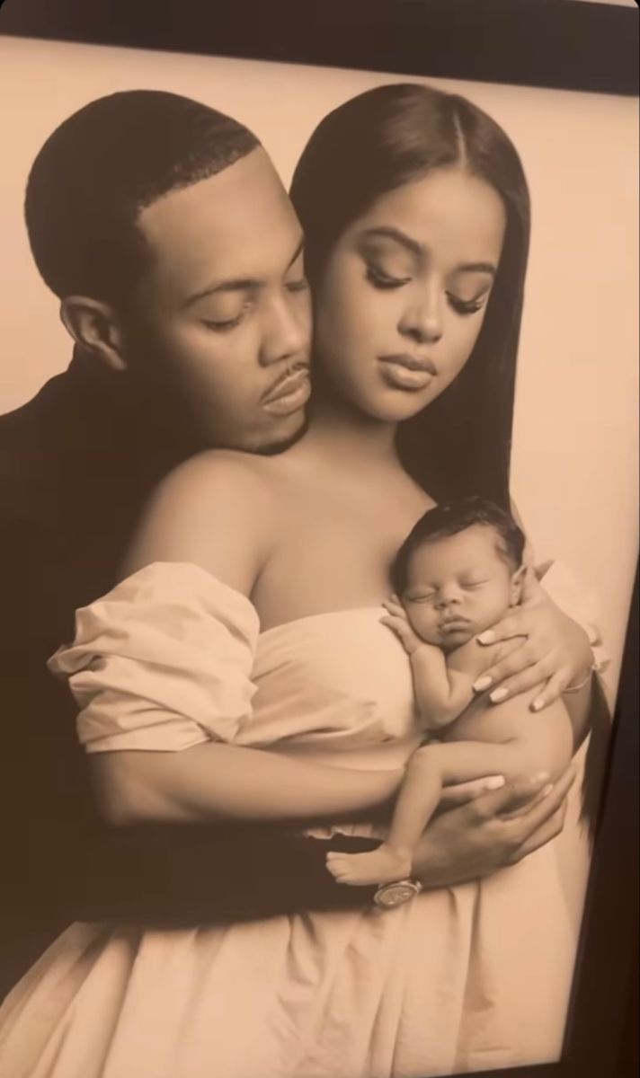 a black and white photo of a couple holding a baby