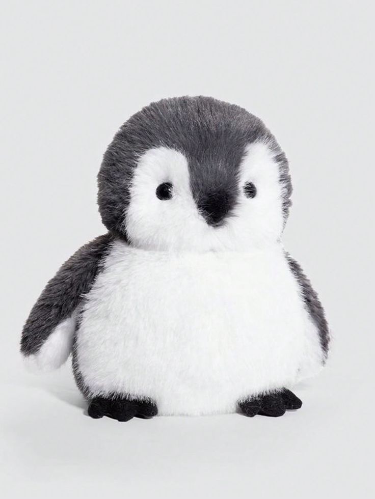 a small stuffed penguin sitting on top of a white floor