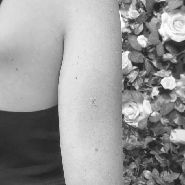 a black and white photo of a woman's arm with the letter k on it