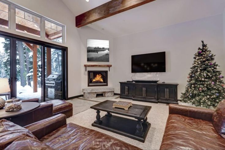 a living room filled with furniture and a christmas tree in front of a flat screen tv