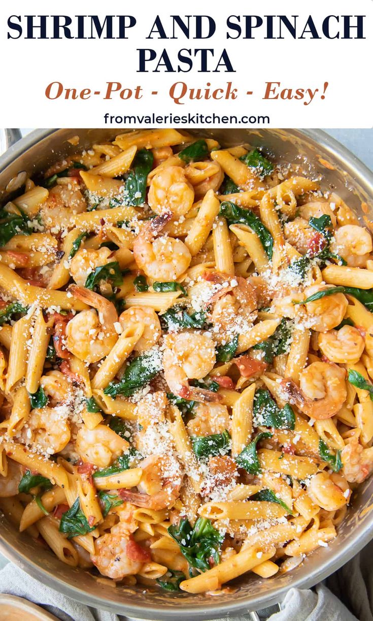 shrimp and spinach pasta in a skillet with parmesan cheese