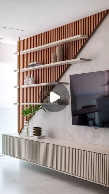 a flat screen tv sitting on top of a wooden shelf next to a white wall