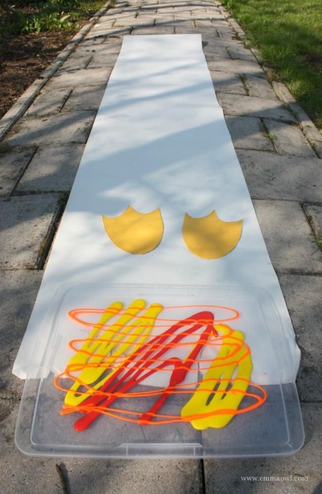 a long white table with some yellow and red items on it in the middle of a sidewalk